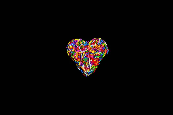 Heart made of colorful sprinkles isolate on black background — Stock Photo, Image
