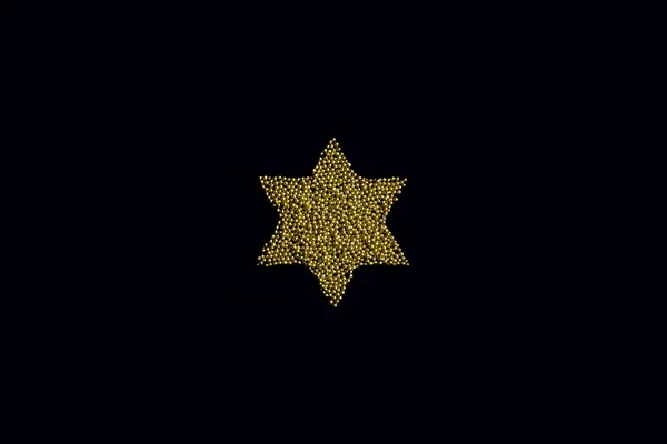 star from edible gold sprinkles on a black background
