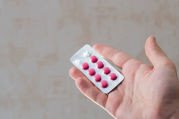 Blister con pillole rosa sul palmo di un uomo . — Foto Stock
