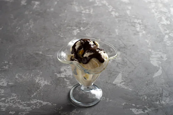 Білі кульки ванільного морозива з шоколадною начинкою в десертному келиху. Прикрашене морозиво на столі з темного, грубого бетону. Копіспазмі . — стокове фото