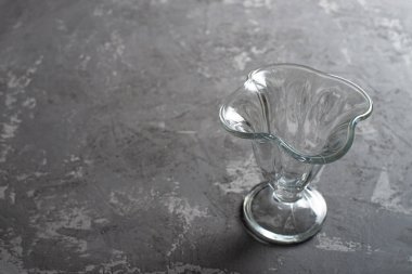 Koyu beton arka planda boş cam dondurma kasesi. Tatlı Fincanı