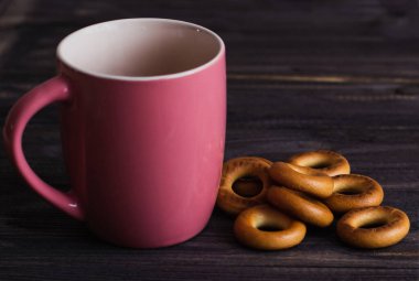 boş kırmızı kupa ve simit siyah ahşap bir masa üzerinde