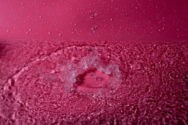 Kırmızı arka planda bir damla su. Soyut duvar kağıdı