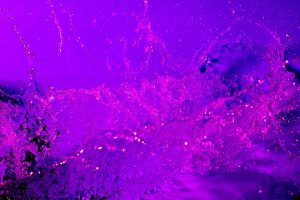 在淡紫色的光线中喷出水花 摘要壁纸 — 图库照片