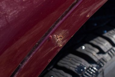 Arabanın vişne rengi paslanmış. Aşınma izleri var. Arka kanat