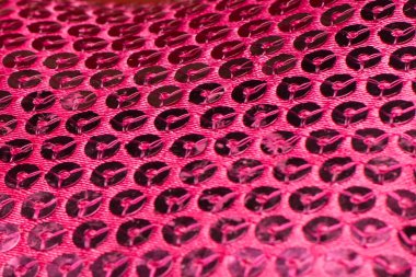 Metal parıltılı kumaş arka plan, yakın çekim. Metalik kumaş dokusu. Pembe pullar, parlak pullu tekstil.