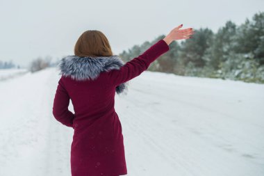 Genç ve güzel bir kız otostopçu kış yolunda araba yakalar.
