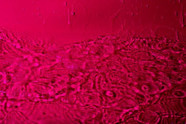 Kırmızı arka planda bir damla su. Soyut duvar kağıdı