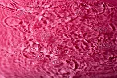 Kırmızı arka planda bir damla su. Soyut duvar kağıdı