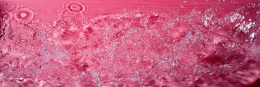 Kırmızı arka planda bir damla su. Soyut duvar kağıdı