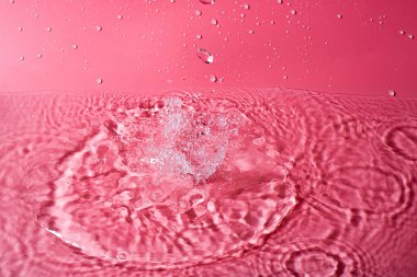 Kırmızı arka planda bir damla su. Soyut duvar kağıdı