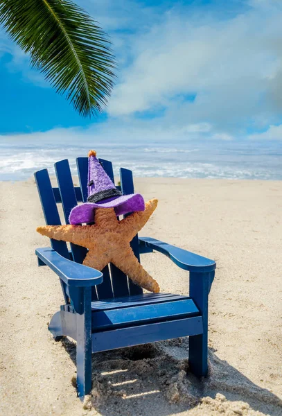 万圣节背景与海星在女巫的帽子上的椅子上 在海边的沙滩上 — 图库照片