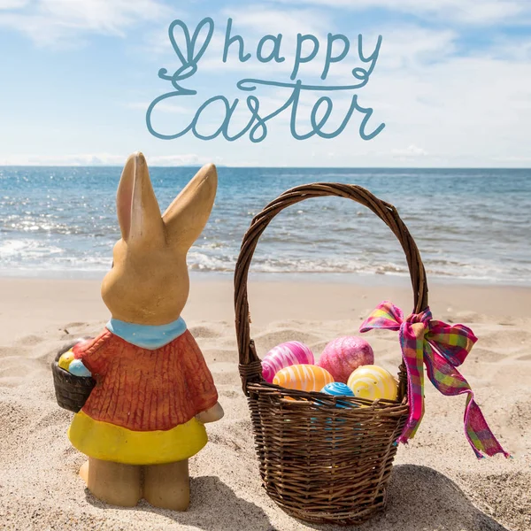 Happy Easter Bunny met mand en kleur eieren op de Ocean Beach — Stockfoto