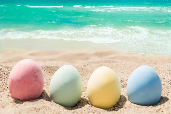 Šťastné Velikonoce na pozadí s vejci na písečné pláži — Stock fotografie