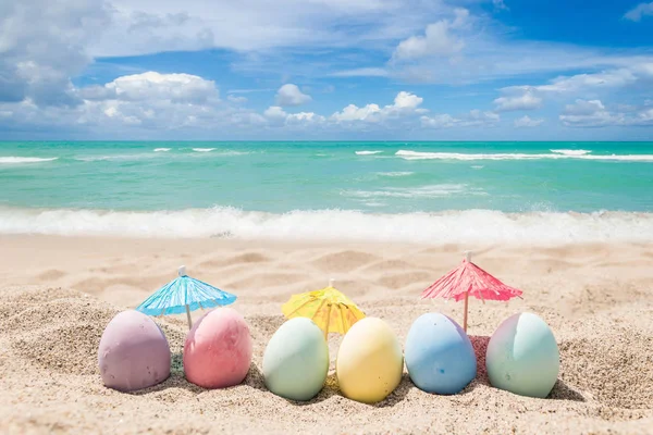 Happy Easter belettering achtergrond met eieren op het zandstrand — Stockfoto