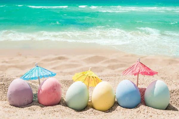 Feliz Páscoa lettering fundo com ovos na praia de areia — Fotografia de Stock