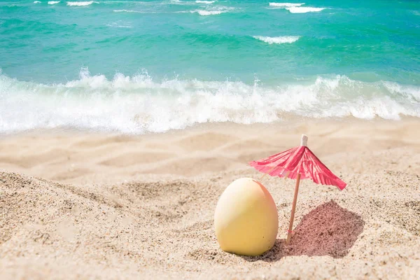 Fondo de letras de Pascua feliz con huevos en la playa de arena — Foto de Stock