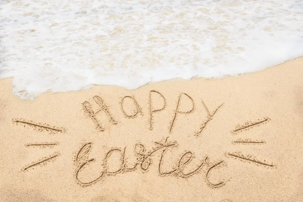 Fondo de letras de Pascua feliz con huevos en la playa de arena Imagen de stock