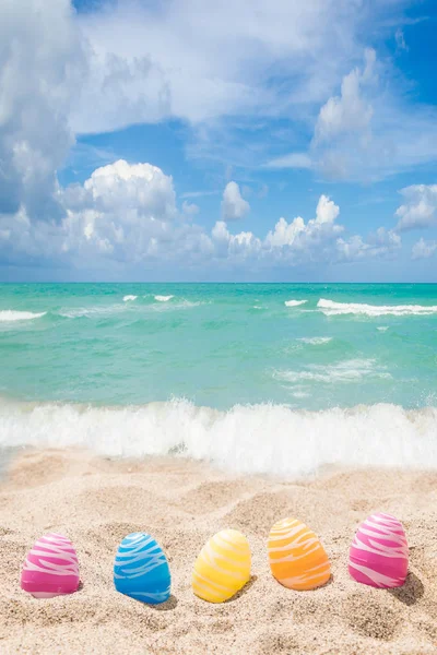 Feliz Páscoa lettering fundo com ovos na praia de areia — Fotografia de Stock