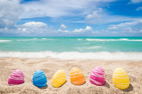 Happy easter lettering background with eggs on the sandy beach — Stock Photo, Image