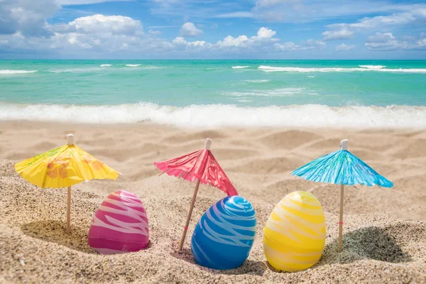 砂浜のビーチで卵とハッピーイースターレタリングの背景 — ストック写真