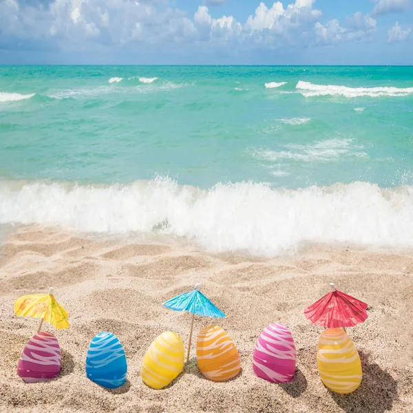 Feliz Páscoa lettering fundo com ovos na praia de areia — Fotografia de Stock