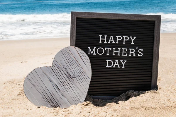 Happy Mothers day beach background with black board and heart