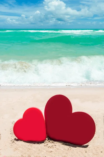 Dos corazones en el fondo de la playa de arena —  Fotos de Stock