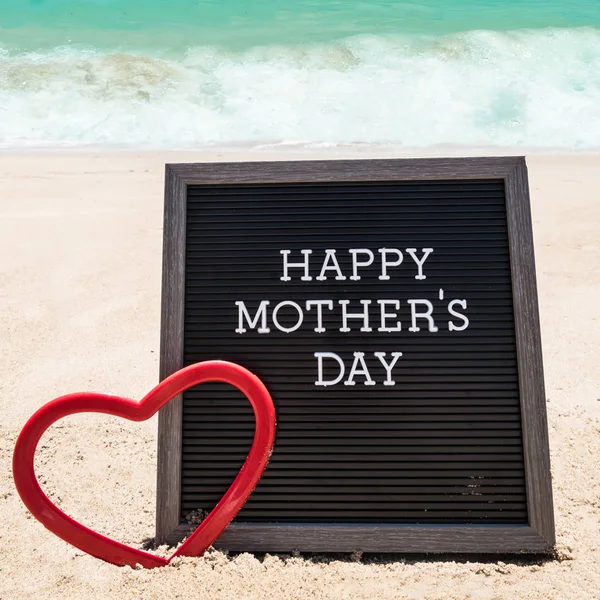 Happy Mothers day beach background with black board and heart