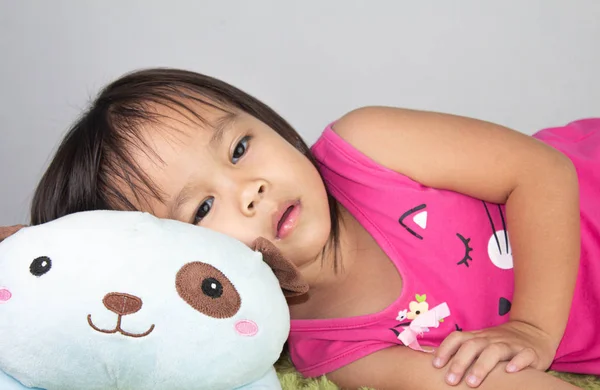 Sleepy pequeña niña asiática en la cama y con vestido rosa —  Fotos de Stock
