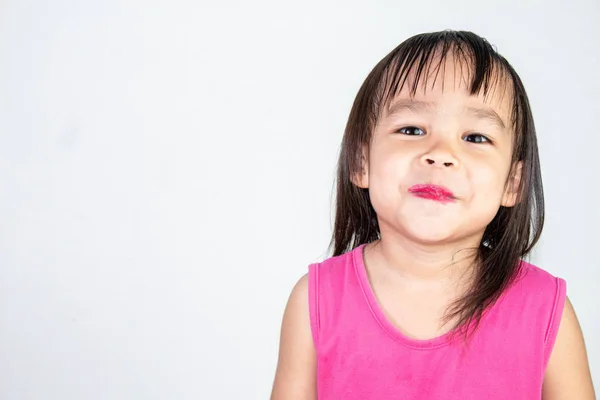 Menina asiática feliz criança com aplicar batom vermelho vestindo rosa dres — Fotografia de Stock