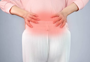 Evde çok çalıştıktan sonra sırt ağrısı çeken bir kadın. Sağlık c