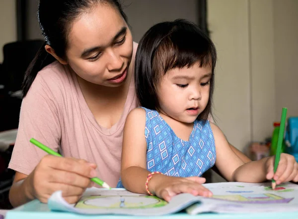 Asian mother helping daughter doing homework after school. Home teaching concept. — Stock Photo, Image