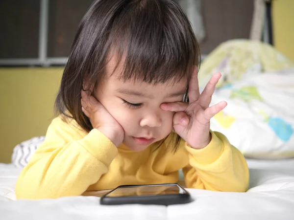 Asiatische kleine Mädchen reiben ihre Augen fühlen sich schmerzhaft nach beobachten s — Stockfoto