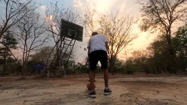 アジアのティーン男遊びバスケットボールとともに家族で屋外スタジアム — ストック動画