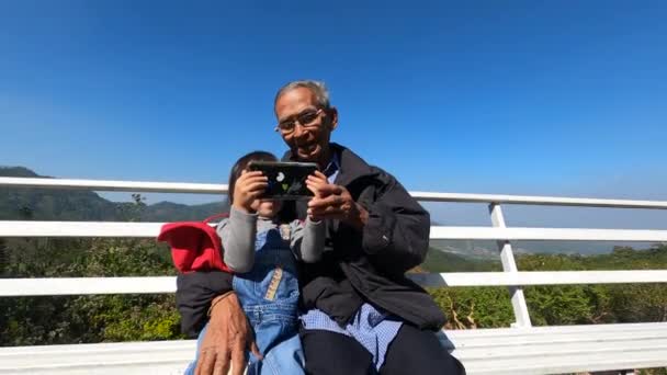 휴대폰을 할아버지와 오렌지 농장에 의자에 셀카를 아시아의 — 비디오