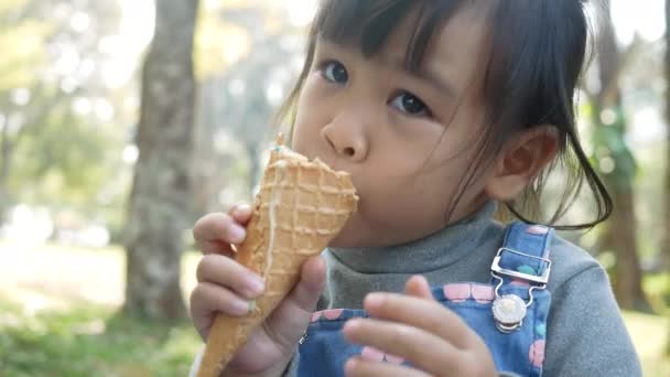 Niña Asiática Disfrutando Comiendo Con Helado Sentada Pastos Parque Día — Vídeos de Stock