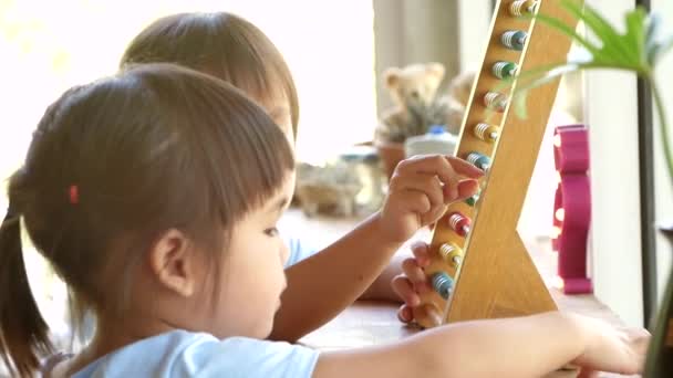 可爱的小女孩学习与教育五彩斑斓的木制算盘和计数室内 学前教育概念的家庭学校 — 图库视频影像