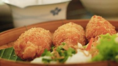 Yemek sepetinde servis edilen şeker kamışlı kızarmış karidesleri toplamak için yakın plan yemek çubuğu kullanılıyor. Vietnam usulü yemek..