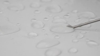 Beyaz arka planda şırınga iğneli su damlaları. Seçici odak.