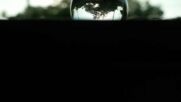 玻璃水晶球中的树与环境倒映在木制桌子上 窗边的房子在自然的背景上 黑白风格的色调 — 图库视频影像