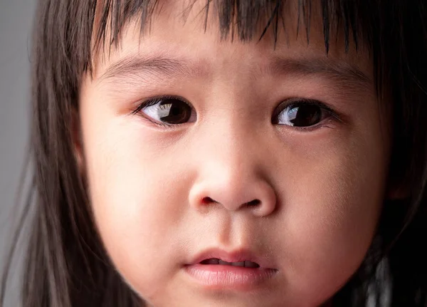 アジアの小さな子供の女の子の肖像画の顔とともに悲しい表情で暗い背景 — ストック写真