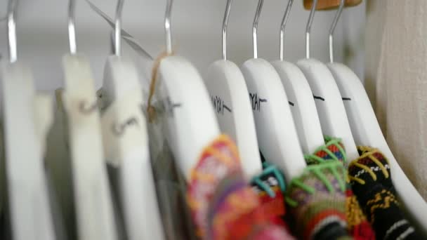 店内の美しい列には 綿の服を着た白い木製のハンガー 選択的焦点 — ストック動画