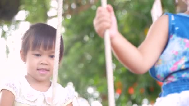 Portré Két Csinos Kislányról Akik Fából Készült Hintákkal Játszanak Kertben — Stock videók