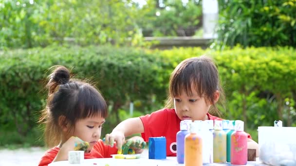 아시아의 자매들은 여름날에 아크릴 페인트로 손으로 손으로 색칠하는 즐긴다 어린이들의 — 비디오