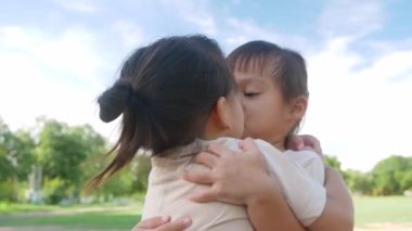 İki kardeş kız kardeş sıcak bir yaz gününde bahçede birbirlerine sarılıp sevgi gösteriyorlar..