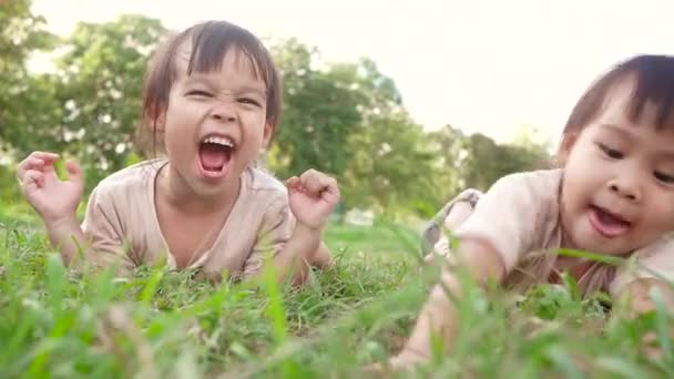Two Happy Sibling Girls Lying Green Grass Outdoors Summer Park — Stock Video