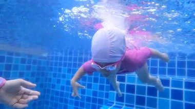 Yüzme havuzuna dalan mutlu kız çocuğu. Aile yaz tatili.