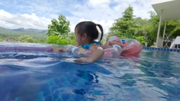 暑い夏の日に家族と一緒にスイミングプールで遊ぶアジアの兄弟姉妹 休暇中の家族の生活 — ストック動画