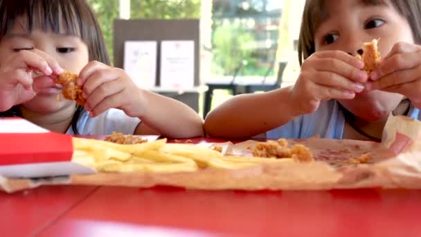 Ευτυχισμένες Ασιάτισσες Αδερφές Απολαμβάνουν Τρώνε Τηγανητό Κοτόπουλο Και Τηγανιτές Πατάτες — Αρχείο Βίντεο